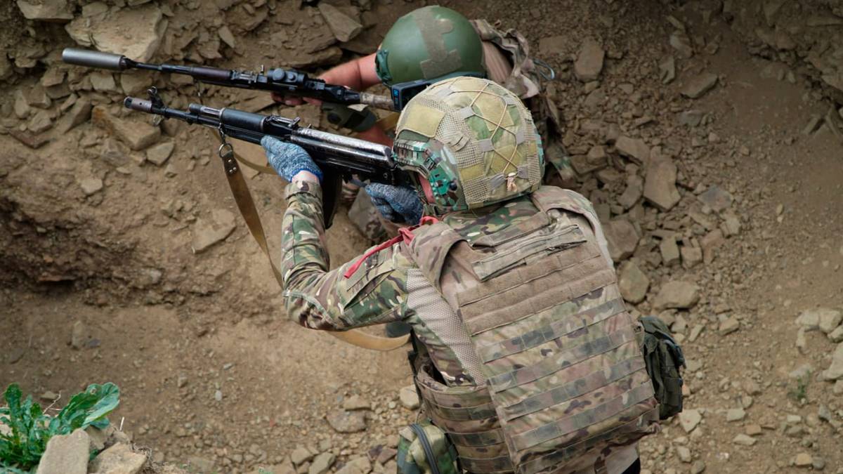 Dw&oacute;ch żołnierzy w kamizelkach taktycznych i hełmach celuje z broni.