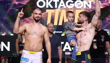 Dw&oacute;ch zawodnik&oacute;w sport&oacute;w walki na scenie, jeden z nich trzyma dziecko.