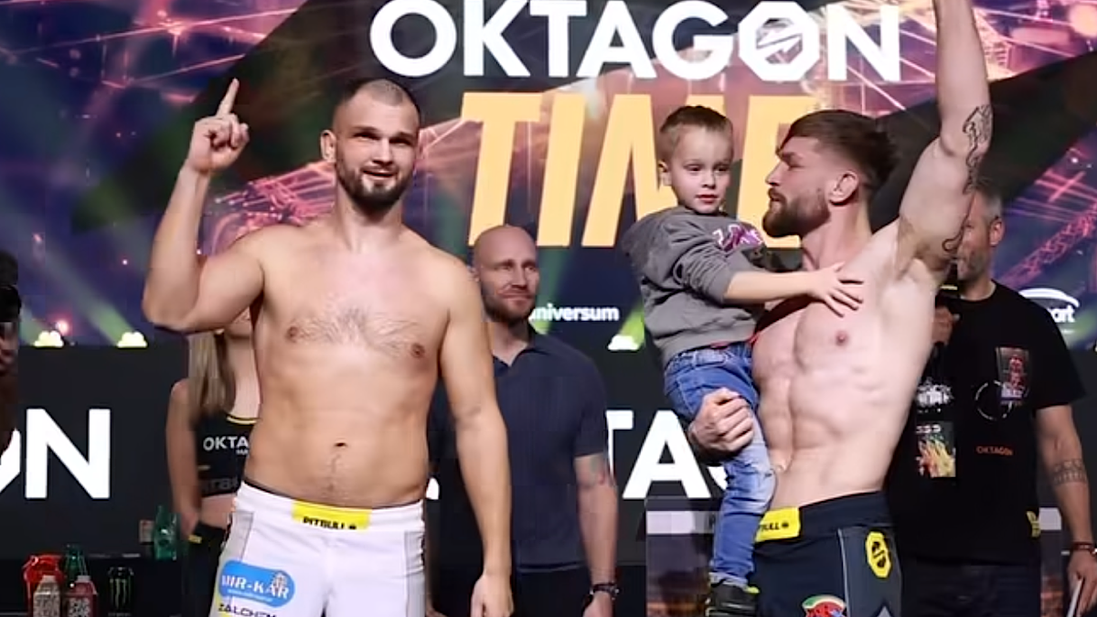 Dw&oacute;ch zawodnik&oacute;w sport&oacute;w walki na scenie, jeden z nich trzyma dziecko.