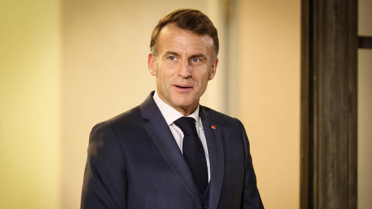 Emmanuel Macron w ciemnym garniturze i białej koszuli z krawatem, lekko uśmiechnięty.