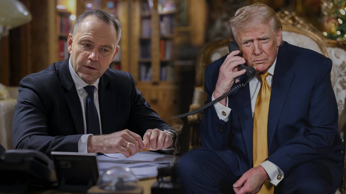 Dw&oacute;ch mężczyzn siedzi przy stole, jeden rozmawia przez telefon, drugi patrzy w bok.