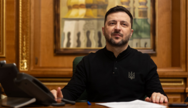 Wołodymyr Zełenski, prezydent Ukrainy, siedzi przy biurku w gabinecie.