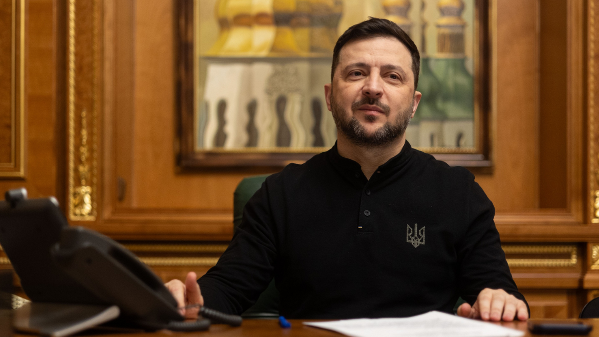 Wołodymyr Zełenski, prezydent Ukrainy, siedzi przy biurku w gabinecie.