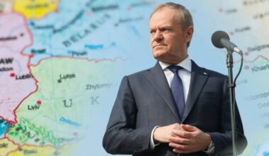 Premier Donald Tusk stoi przed mapą Europy, na kt&oacute;rej zaznaczone są granice państw.