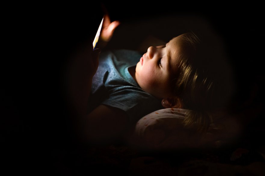 Dziecko korzystające z telefonu (zdjęcie ilustracyjne)