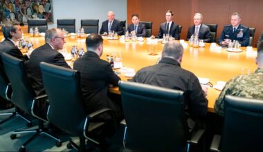 Grupa mężczyzn siedzi przy stole konferencyjnym podczas spotkania.