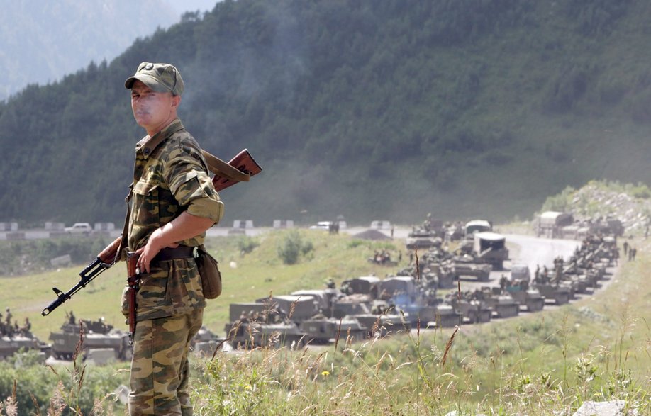 Rosyjski żołnierz na tle kolumny wojsk. Cchinwali, 9 sierpnia 2008 r. 