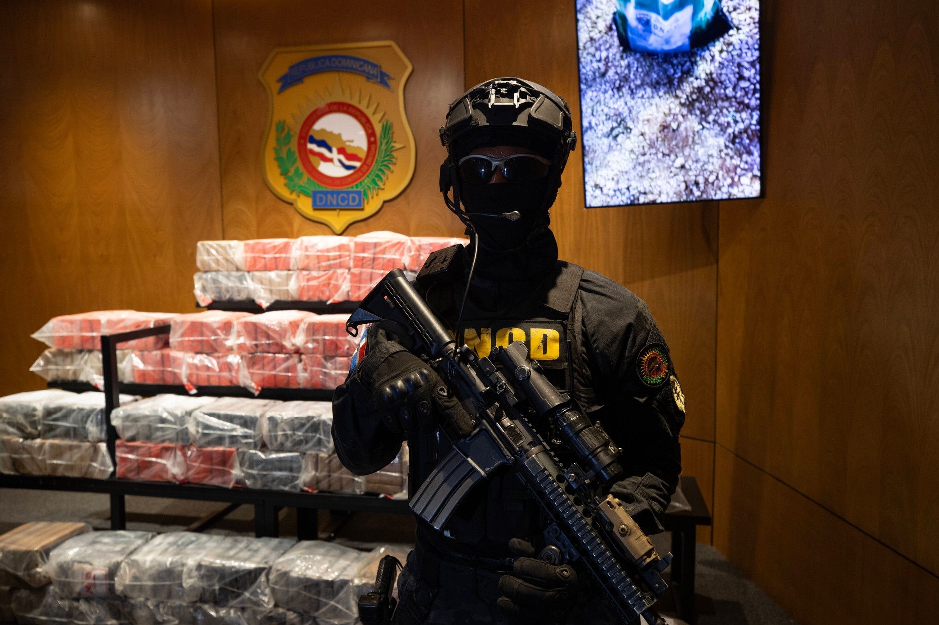 Członek Krajowej Dyrekcji Kontroli Narkotyków pilnujący paczek z kokainą, które znajdowały się na pokładzie łodzi  zbombardowanej przez armię Stanów Zjednoczonych na wodach Karaibów, w Santo Domingo, Dominikana, 21 września 2025 r. 