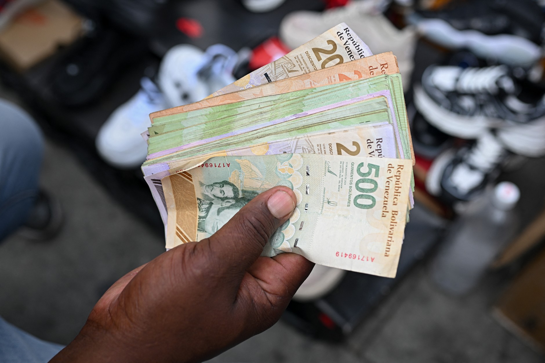 Sprzedawca liczy banknoty na targu w Caracas, 23 grudnia 2025 r.