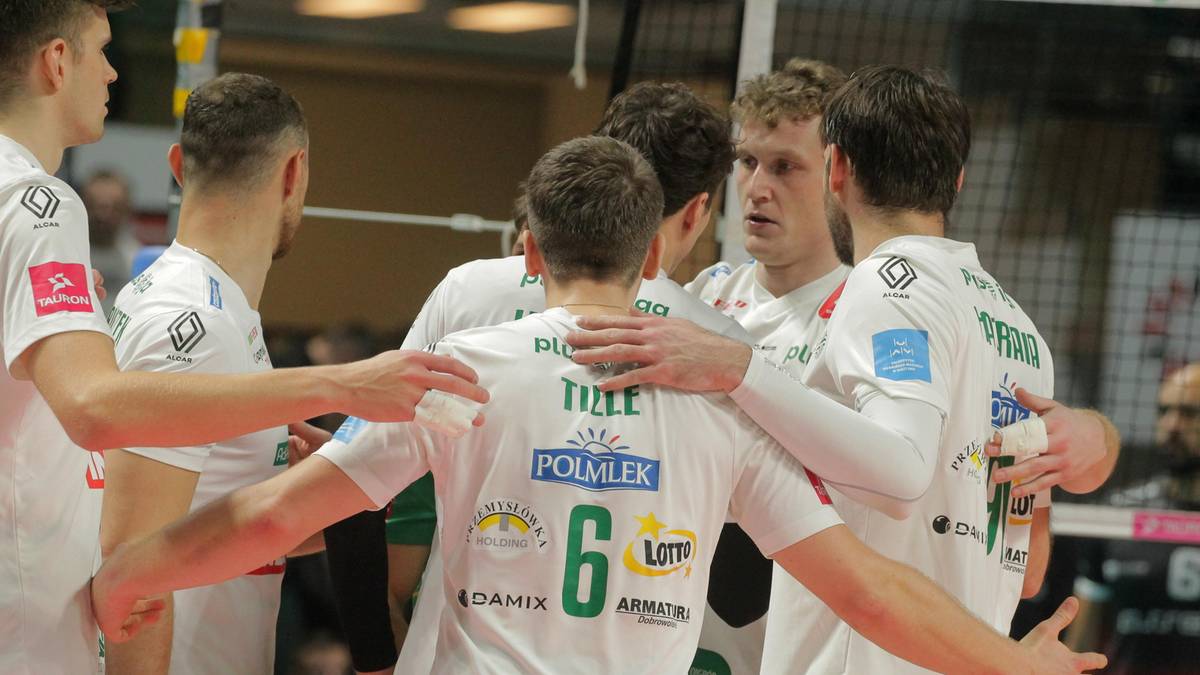 Grupa siatkarzy w białych koszulkach świętuje na boisku, jeden z nich ma na plecach napis "TILLE" i numer "6".