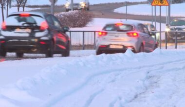 Dwa samochody osobowe stoją na zaśnieżonej drodze, widoczne ślady opon na śniegu.