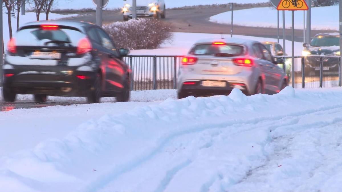 Dwa samochody osobowe stoją na zaśnieżonej drodze, widoczne ślady opon na śniegu.