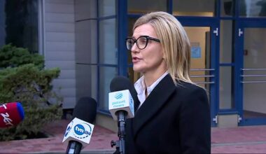 Prokurator Ewa Wrzosek w okularach i czarnym żakiecie przemawia do mikrofon&oacute;w.