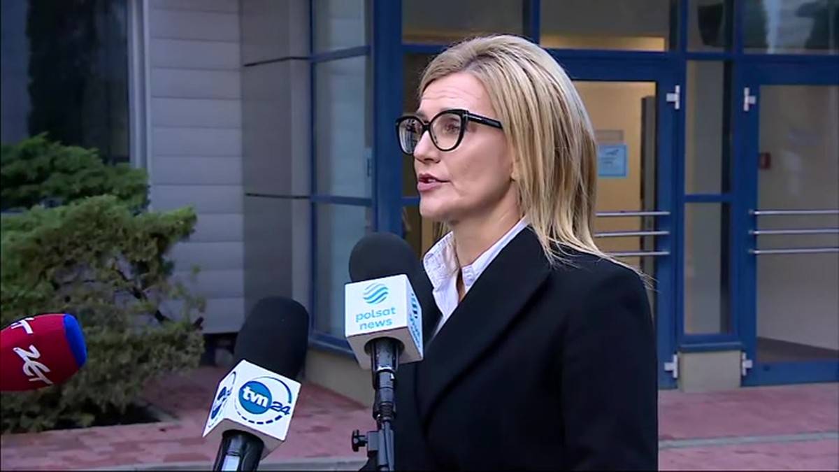 Prokurator Ewa Wrzosek w okularach i czarnym żakiecie przemawia do mikrofon&oacute;w.