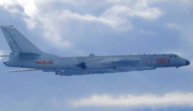 Chiński samolot wojskowy H-6K w locie na tle nieba z chmurami.