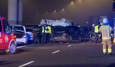 Na drodze w nocy, w gęstej mgle, doszło do karambolu z udziałem wielu samochod&oacute;w. Widać służby ratunkowe i zniszczone pojazdy.
