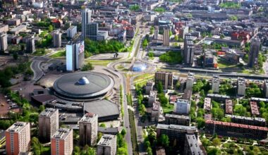 Widok z lotu ptaka na nowoczesne centrum miasta z drogami, budynkami, rondem i charakterystycznym okrągłym budynkiem.