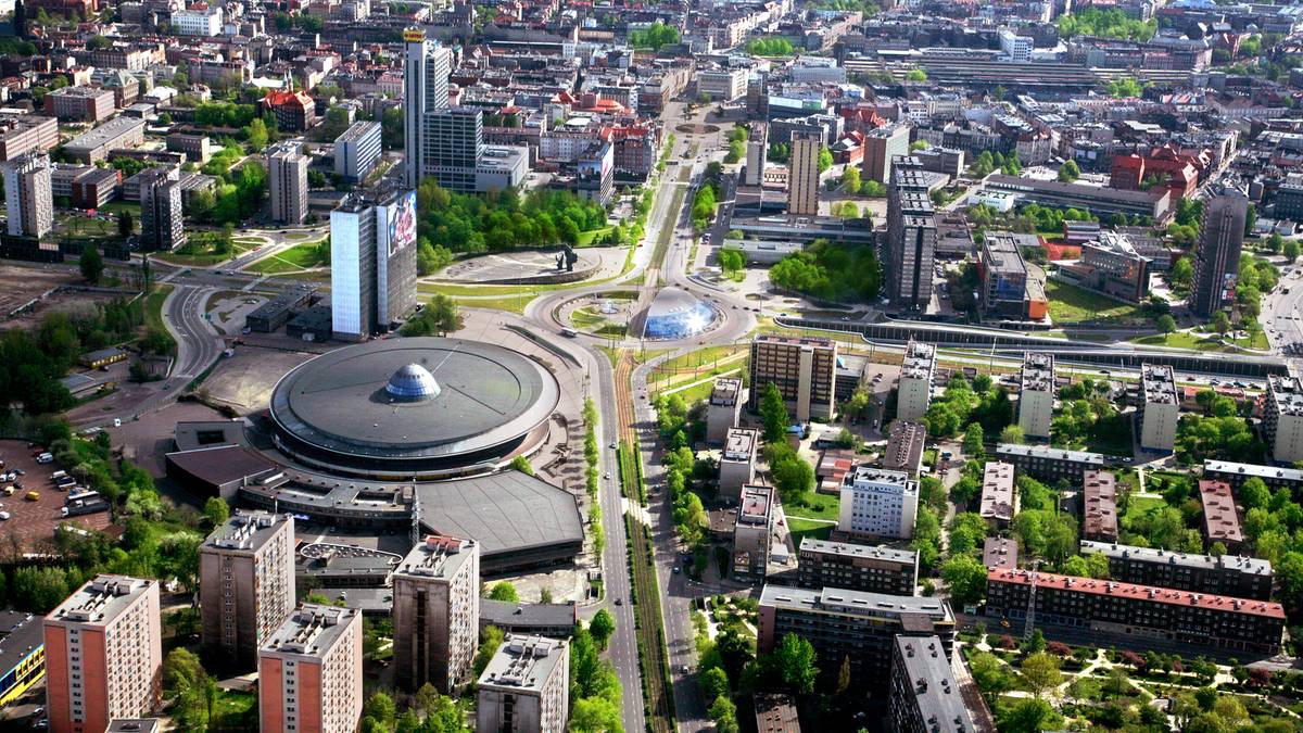 Widok z lotu ptaka na nowoczesne centrum miasta z drogami, budynkami, rondem i charakterystycznym okrągłym budynkiem.