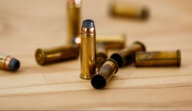 Zbliżenie na kilka nabojów kalibru .45 ACP leżących na drewnianej powierzchni.