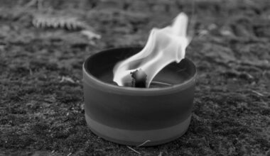 Płonący knot w małym naczyniu na tle ziemi.