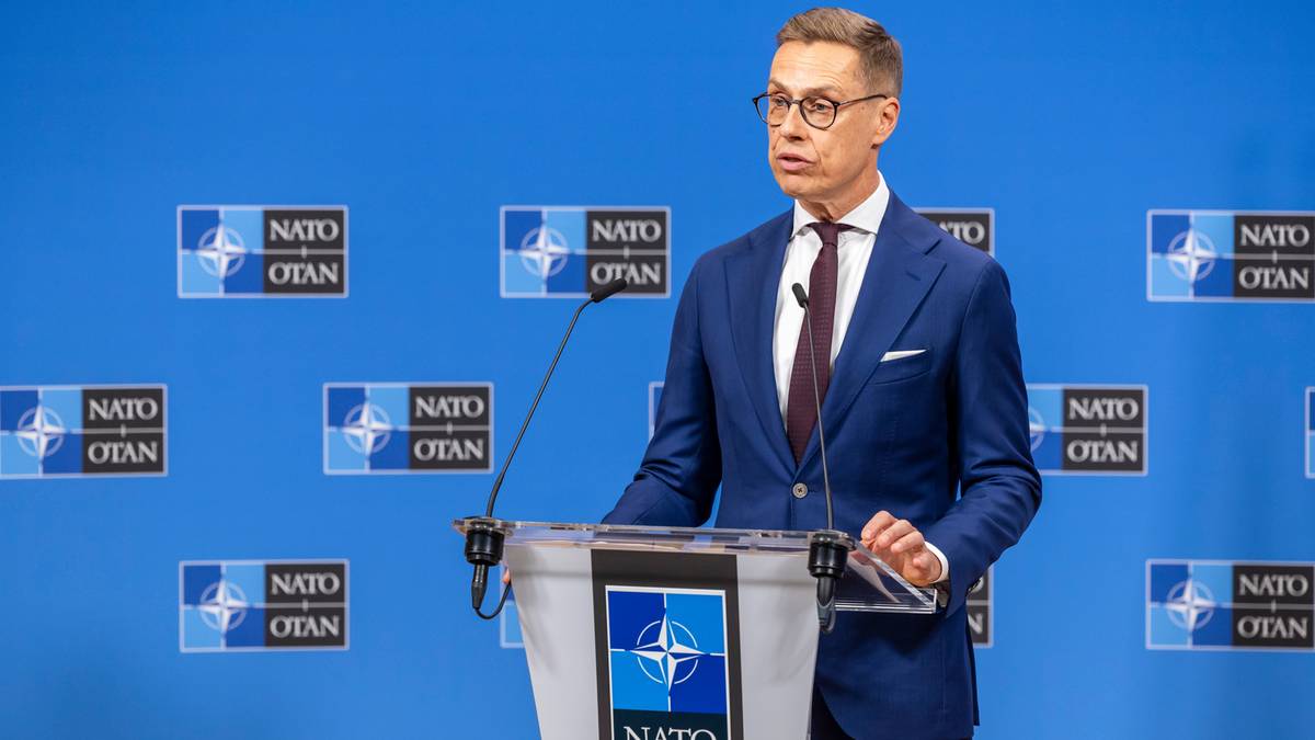 Prezydent Finlandii Alexander Stubb przemawia za mównicą na tle ścian z logo NATO.