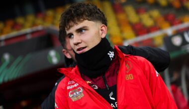 Młody piłkarz w czerwonej kurtce i czarnej kominiarce na szyi