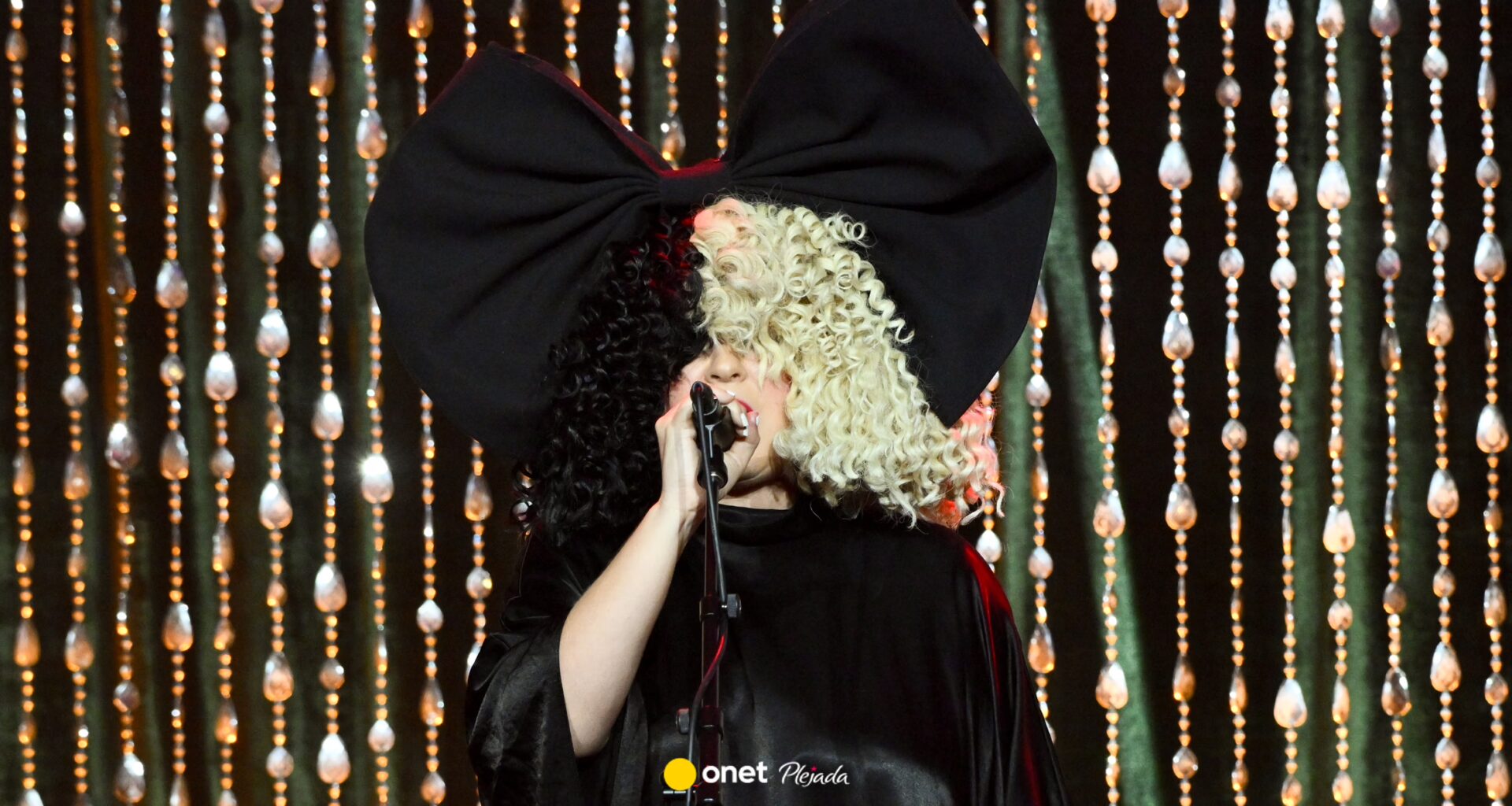 Sia zasłania twarz przed blaskiem fleszy. W cieniu kryje się historia tragedii