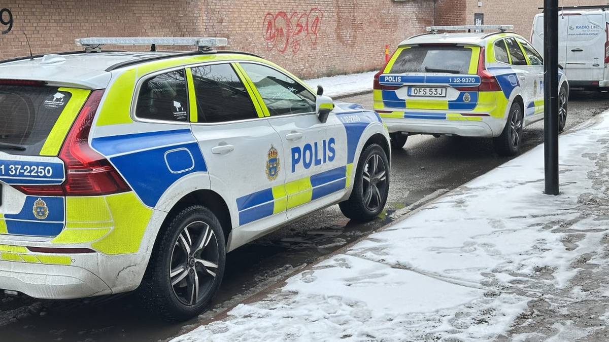 Dwa radiowozy policyjne zaparkowane na zaśnieżonej ulicy w Szwecji.