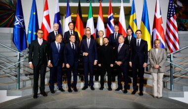 Grupa europejskich lider&oacute;w, w tym prezydent Ukrainy Wołodymyr Zełenski, pozuje do zdjęcia na tle flag narodowych i flagi NATO.