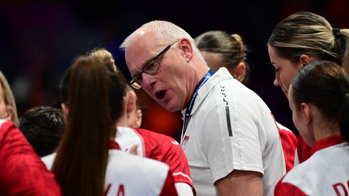 Trener piłki ręcznej Polski mężczyzna w okularach przemawia do zawodniczek w czerwonych strojach.