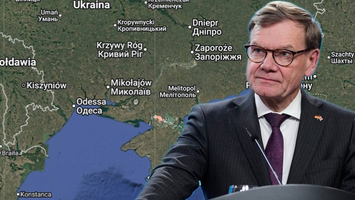 Johann Wadephul stoi przy m&oacute;wnicy na tle mapy Europy Wschodniej z zaznaczoną Ukrainą.