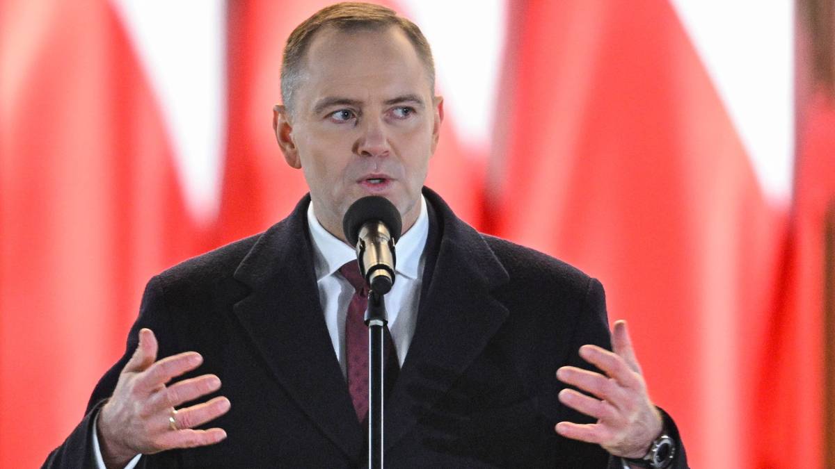 Cezary Tomczyk przemawia do mikrofonu.