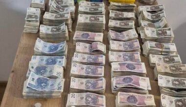 Stosy polskich banknot&oacute;w o r&oacute;żnych nominałach, ułożone na drewnianym stole.