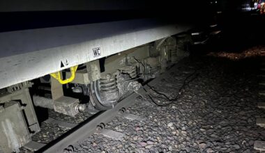 Widok z bliska na podwozie pociągu stojącego na torach kolejowych.