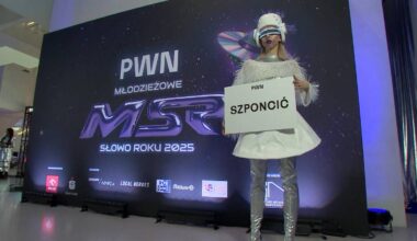 Kobieta w futurystycznym stroju trzyma tabliczkę z napisem "SZPONCIĆ" na tle ekranu z logo plebiscytu "Młodzieżowe Słowo Roku".