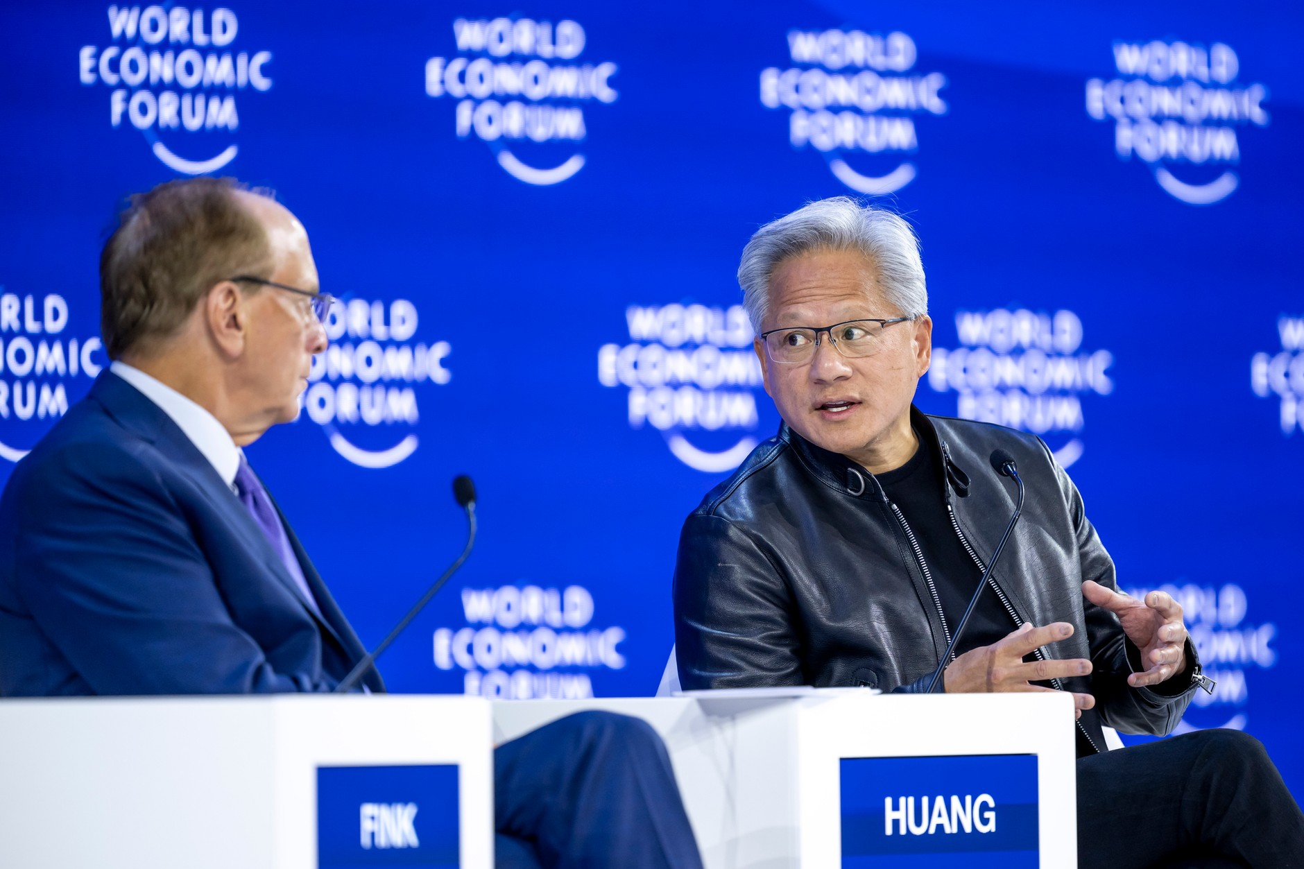 Prezes BlackRock i współprzewodniczący WEF Larry Fink (L) oraz założyciel i dyrektor generalny Nvidia Jensen Huang uczestniczący w panelu dyskusyjnym podczas Światowego Forum Ekonomicznego (WEF) w Davos w Szwajcarii, 21 stycznia 2026 r.
