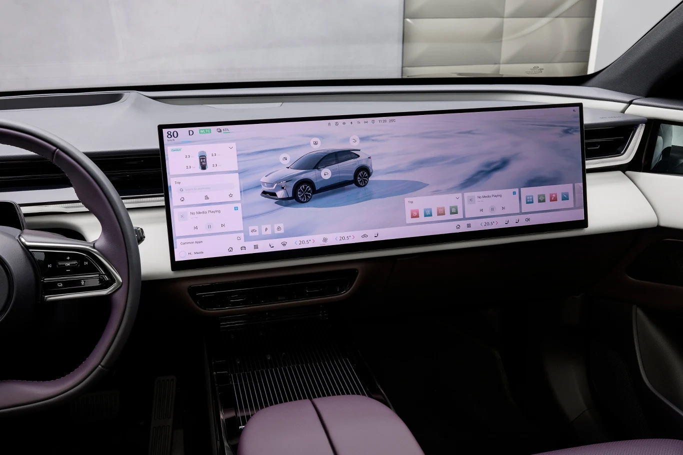 Mazda CX-6e Wnętrze nowoczesnego samochodu z szerokim, panoramicznym ekranem dotykowym na desce rozdzielczej. Na ekranie widoczna wizualizacja pojazdu oraz interfejs sterowania funkcjami samochodu.