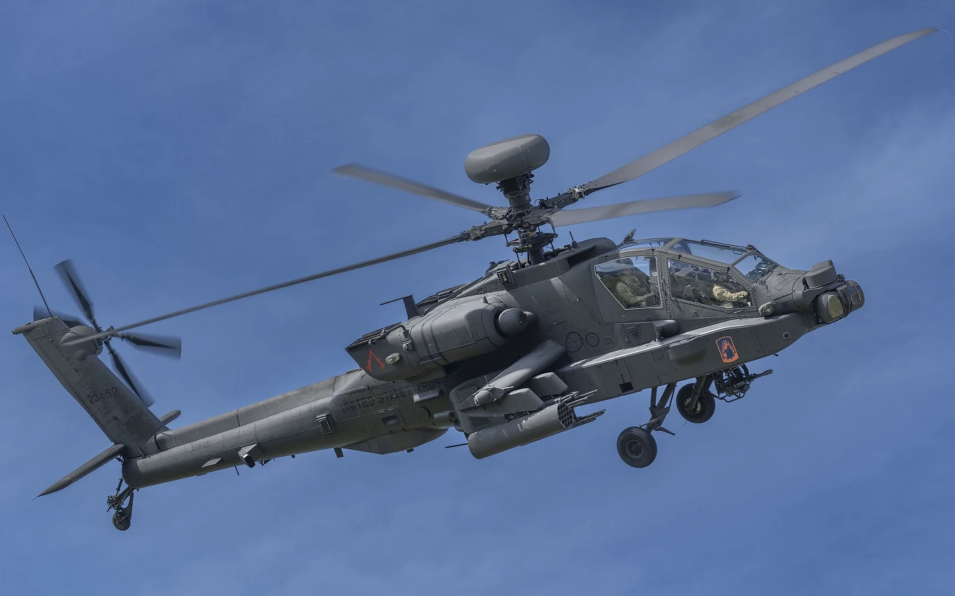 Polska flota 96 Apache będzie pierwszą, która pozyska specjalne systemy elektroniczne Gen 4 TADS/PNVS Helikopter bojowy w locie na tle nieba, z widocznymi uzbrojeniem, wirnikiem oraz kokpitem z dwoma członkami załogi.