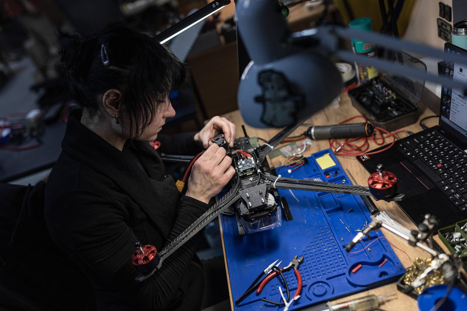 Żołnierka z Brygady Gwardii Narodowej AZOV przygotowująca drona do transmisji sygnału, obwód doniecki, Ukraina, 29 grudnia 2025 r. 