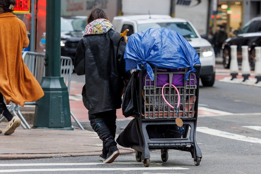 Osoba w kryzysie bezdomności przewozi swoje rzeczy w wózku. Nowy Jork, 29 stycznia 2024 r.