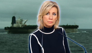 Maria Zacharowa, rzeczniczka rosyjskiego MSZ, na tle statku towarowego na morzu.