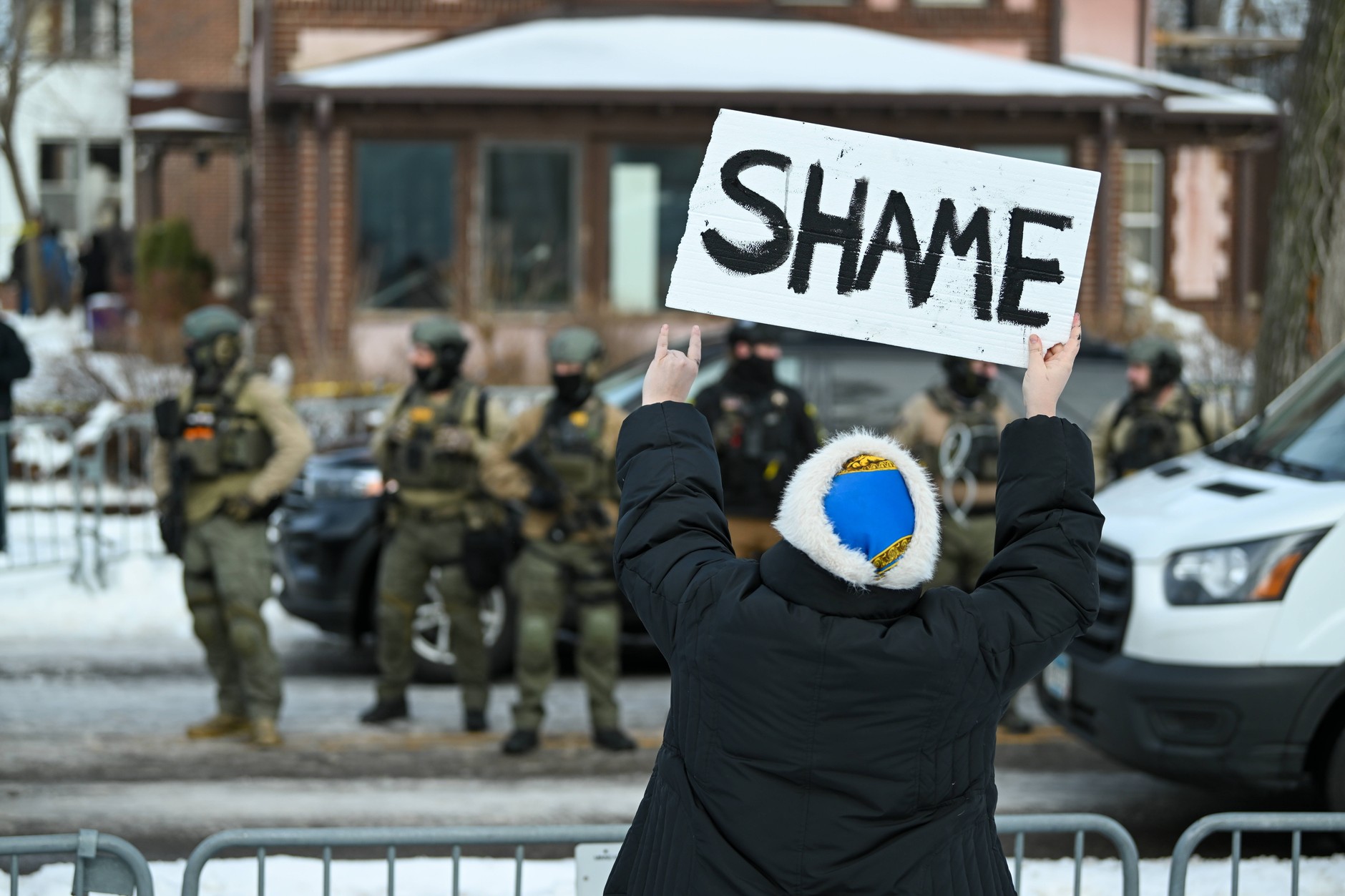 Protestujący trzyma transparent na miejscu, gdzie kobieta została postrzelona i zabita przez agenta Immigration and Customs Enforcement (ICE) w Minneapolis w stanie Minnesota w USA, 7 stycznia 2026 r. 