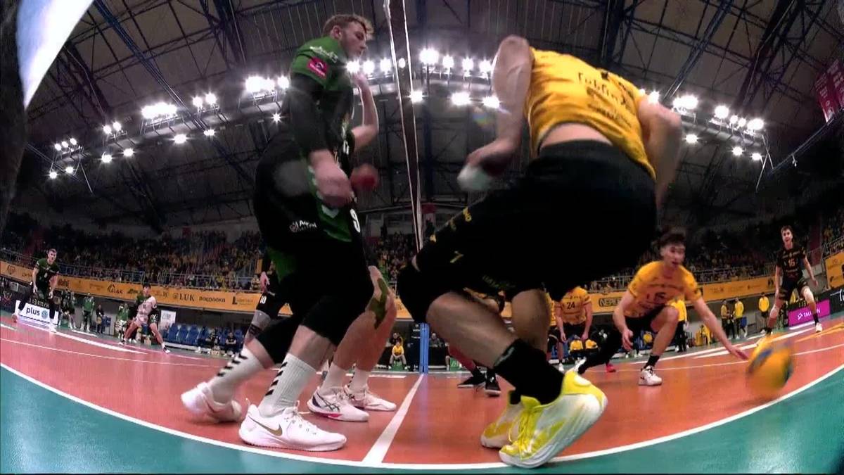 Siatkarze w akcji podczas meczu w hali sportowej.