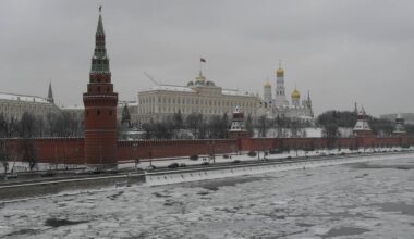 Widok na Kreml w zimowy dzień, z rzeką pokrytą lodem w pierwszym planie.