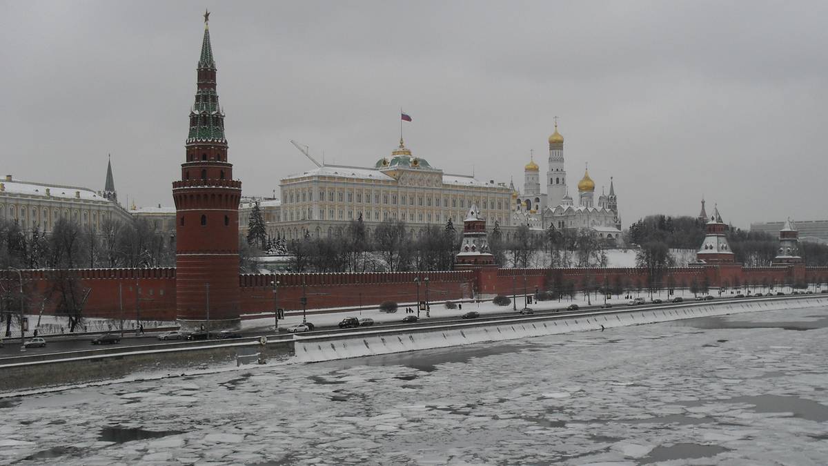 Widok na Kreml w zimowy dzień, z rzeką pokrytą lodem w pierwszym planie.