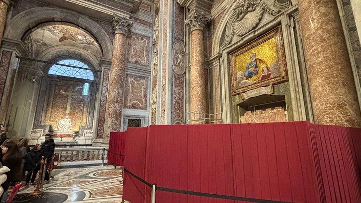 Wnętrze bazyliki z czerwonymi barierkami i fragmentem ołtarza.