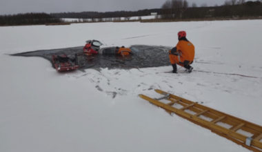 Akcja ratunkowa na lodzie, ratownicy wyciągają samoch&oacute;d spod wody.