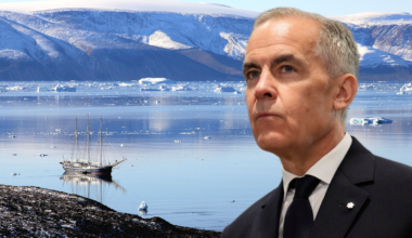 Mężczyzna w garniturze na tle lodowatego krajobrazu z żaglowcem na wodzie.