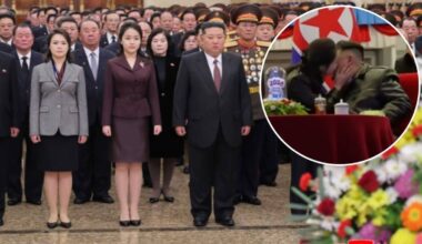 Grupa os&oacute;b w formalnych strojach, z Kim Dzong Unem i jego żoną na pierwszym planie. W prawym g&oacute;rnym rogu znajduje się zbliżenie na Kima Dzong Una całującego inną kobietę.