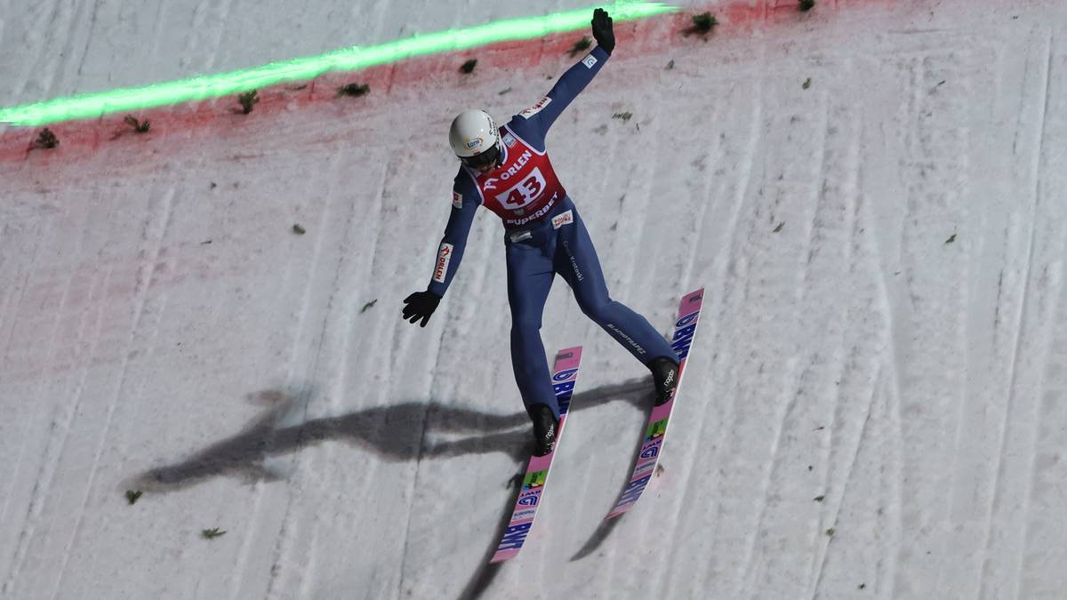 Skoczek narciarski w powietrzu podczas zawod&oacute;w na Wielkiej Krokwi.